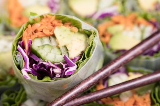 Vegetarian spring rolls with avocado, carrots, cucumber and red cabbage.