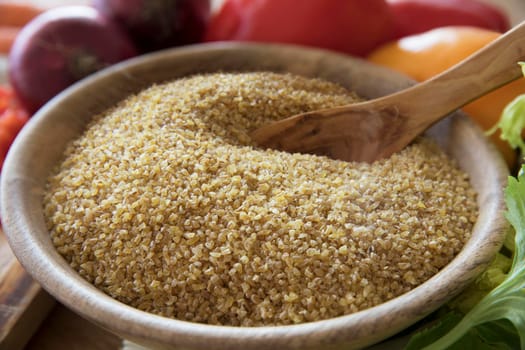 Wooden bowl full of fresh bulgur