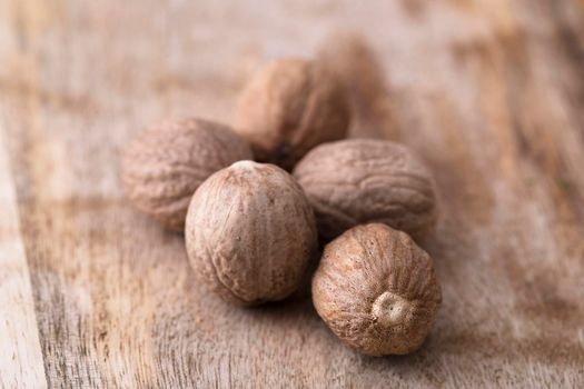 Whole nutmeg on rustic wooden surface