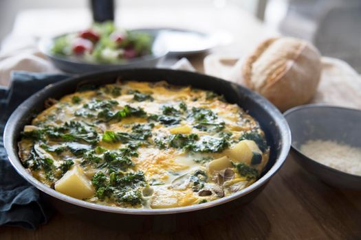 Delicious frittata with kale and potatoes in pan
