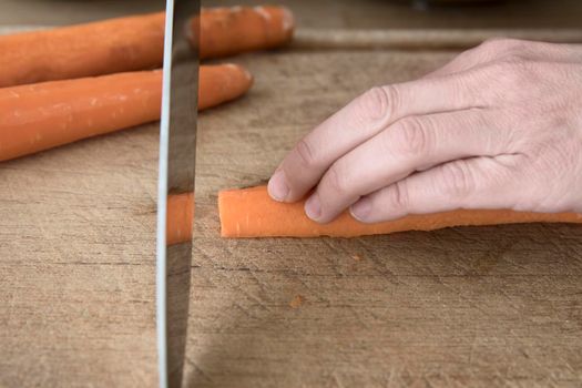 Knife skills cutting a carrot: the wrong way to hold your fingers when cutting food.