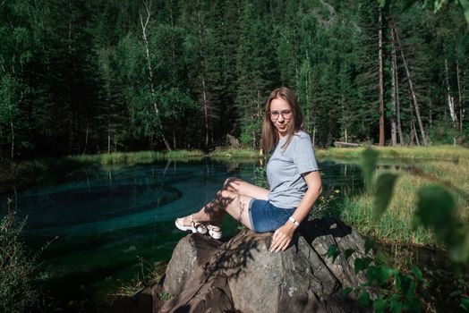 Woman resting at mountain lake in summer, Altai mountains