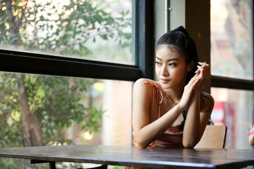 elegant sensual young woman in brown dress on recamier outdoor shot