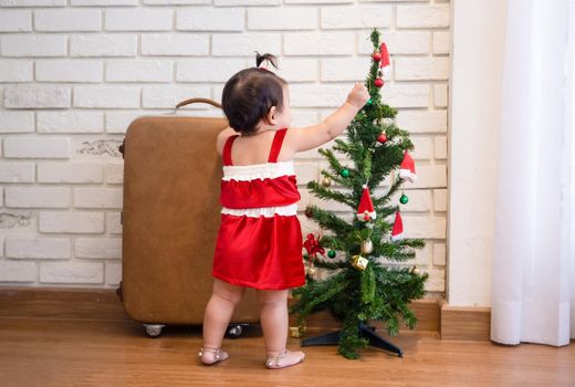 Full Length Of Cute Baby Girl Wearing Santa Costume While Sitting With Christmas Decorations