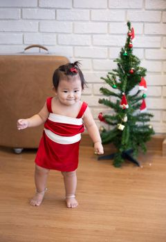 Full Length Of Cute Baby Girl Wearing Santa Costume While Sitting With Christmas Decorations