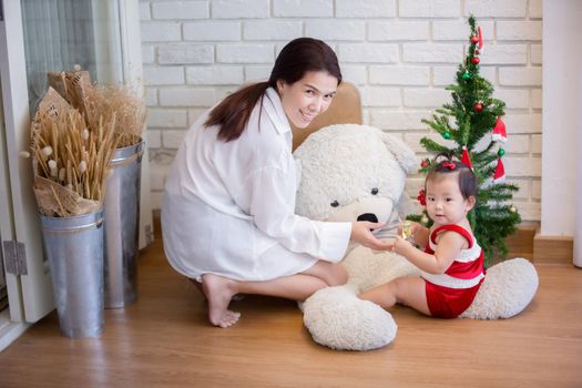 Full Length Of Cute Baby Girl Wearing Santa Costume While Sitting With Christmas Decorations