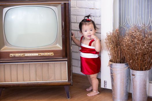 Full Length Of Cute Baby Girl Wearing Santa Costume While Sitting With Christmas Decorations