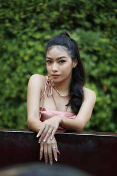 elegant sensual young woman in brown dress on recamier outdoor shot