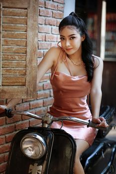 elegant sensual young woman in brown dress on recamier outdoor shot