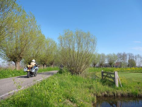 motorcycles on country road near worden in the netherlands on spring day under blue sky near Woerden in the green heart of holland