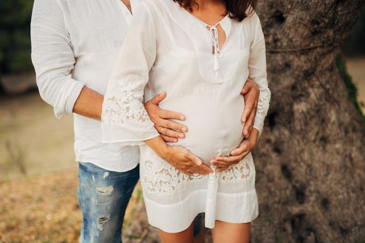 Pregnant woman holding belly with hands in Montenegro
