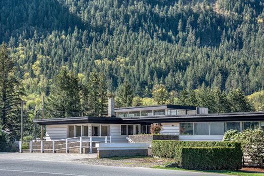 A perfect neighbourhood. Office building on mountain slope background.