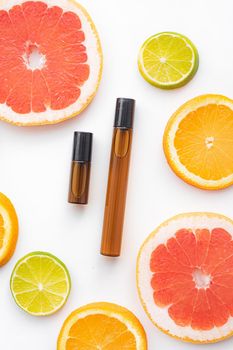 Cosmetic roller oil and citrus fruits . Cosmetic procedures. Healthy skin. Skin care. Citrus oil. White background. Copy space. Article about care cosmetics