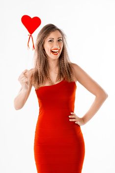 Beautiful cheerful girl standing and holding red heart.