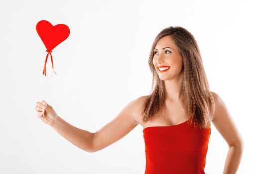 Beautiful happy smiling girl standing and holding red heart.