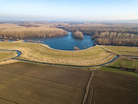 Aerial panorama view of agricultural fields, river and autumn forest at the sunset.