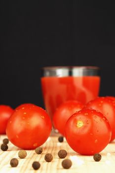 Ripe red tomatoes and tomato juice in a transparent glass glass. High quality photo