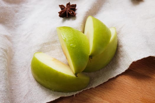 sliced green apple on wooden linen cloth.