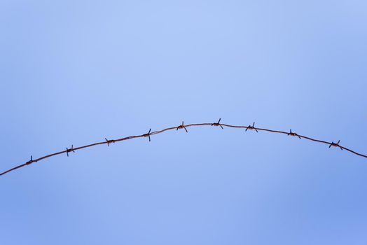 barbed wire against a blue sky background.