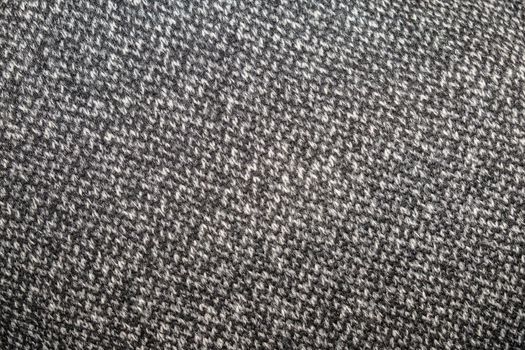 Heather grey knitted fabric made of synthetic yarn. Textured background.