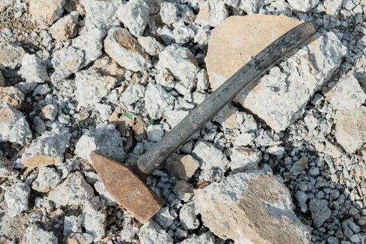 iron hammer breaking stone into pieces. Large sledgehammer for construction.