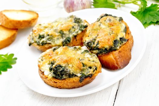 Hot sandwiches with nettles and cheese on slices of wheat bread in a plate on a wooden board background