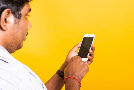 Closeup Asian happy portrait young black man holding digital mobile smartphone blank screen space on hands, studio isolated on yellow background