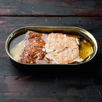 Canned Smoked Trout Fillets set, in tin can, on old dark wooden table background, square format
