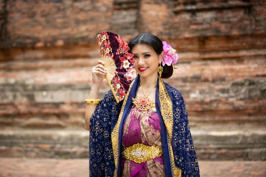 Indonesia Young beautiful woman with Traditional dress standing and look at camera at Gate to heaven Handara Golf Gate in Bedugul, Bali ,Indonesia.