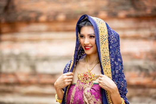 Indonesia Young beautiful woman with Traditional dress standing and look at camera at Gate to heaven Handara Golf Gate in Bedugul, Bali ,Indonesia.