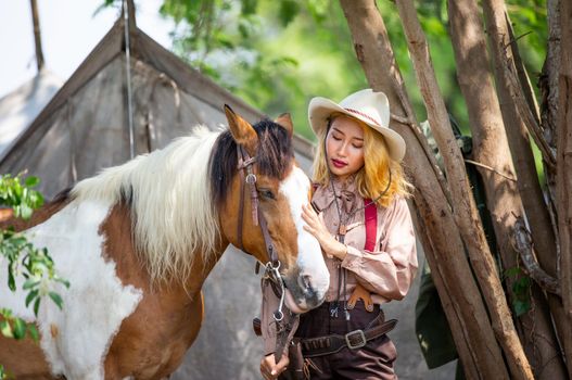 Cowgirl standing by horse, westlife and outdoor.