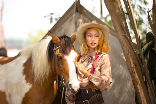 Cowgirl standing by horse, westlife and outdoor.