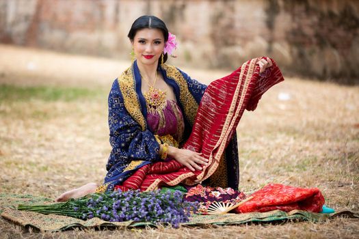 Indonesia Young beautiful woman with Traditional dress standing and look at camera at Gate to heaven Handara Golf Gate in Bedugul, Bali ,Indonesia.