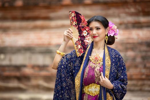Indonesia Young beautiful woman with Traditional dress standing and look at camera at Gate to heaven Handara Golf Gate in Bedugul, Bali ,Indonesia.