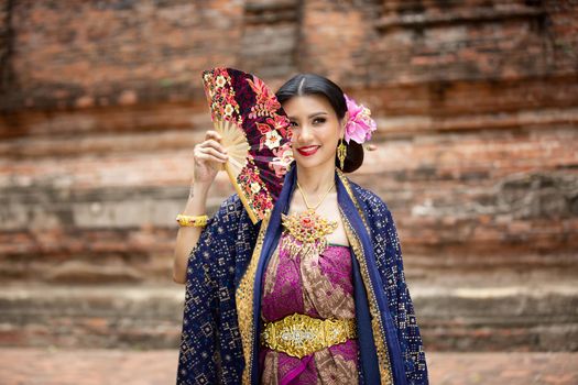 Indonesia Young beautiful woman with Traditional dress standing and look at camera at Gate to heaven Handara Golf Gate in Bedugul, Bali ,Indonesia.