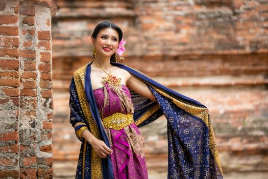 Indonesia Young beautiful woman with Traditional dress standing and look at camera at Gate to heaven Handara Golf Gate in Bedugul, Bali ,Indonesia.