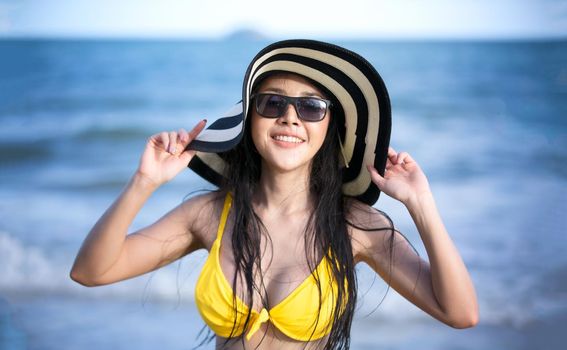 Beautiful young woman in sexy bikini on sand at sea beach.