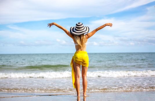 Beautiful young woman in sexy bikini on sand at sea beach.