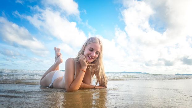 Beautiful young woman in sexy bikini on sand at sea beach.