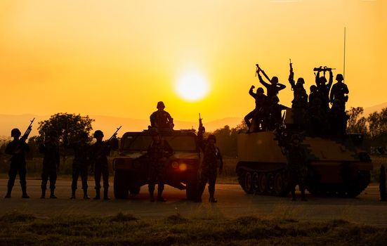 Silhouettes of soldiers during Military Mission at dusk
Silhouettes of army soldiers in the fog against a sunset, marines team in action, surrounded fire and smoke, shooting with assault rifle and machine gun, attacking enemy
