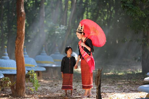 Beautiful thai girl woman wearing native culture dresses spending time with elephant in the jungle at countryside, elephant village Surin, Thailand
