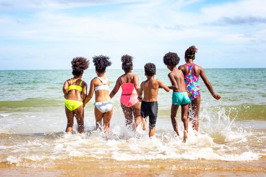 Kids playing running on sand at the beach