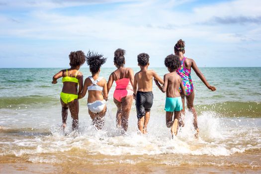 Kids playing running on sand at the beach