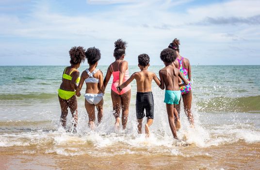 Kids playing running on sand at the beach