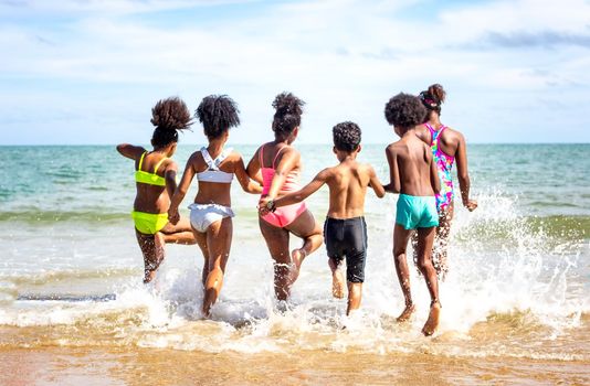 Kids playing running on sand at the beach