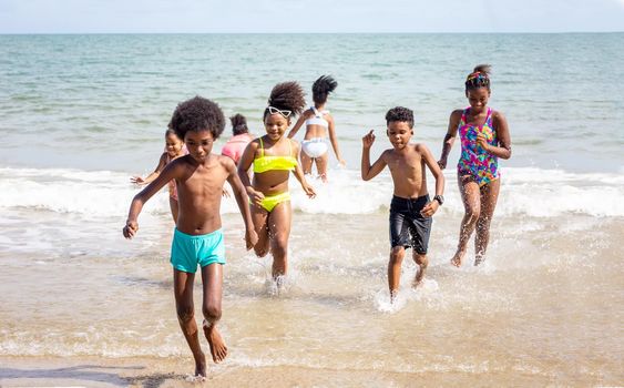 Kids playing running on sand at the beach