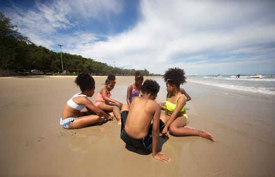 Kids playing running on sand at the beach