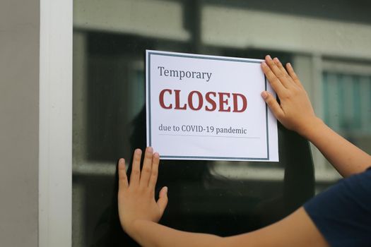 Closed businesses for COVID-19 pandemic outbreak, closure sign on retail store window banner background. Government shutdown of restaurants, shopping stores, non essential services.