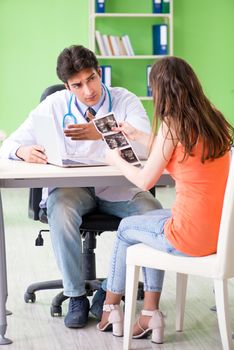 Pregnant woman visiting male gynecologyst at the clinic 