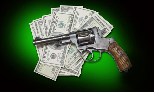 old revolver and money on a darkly green background